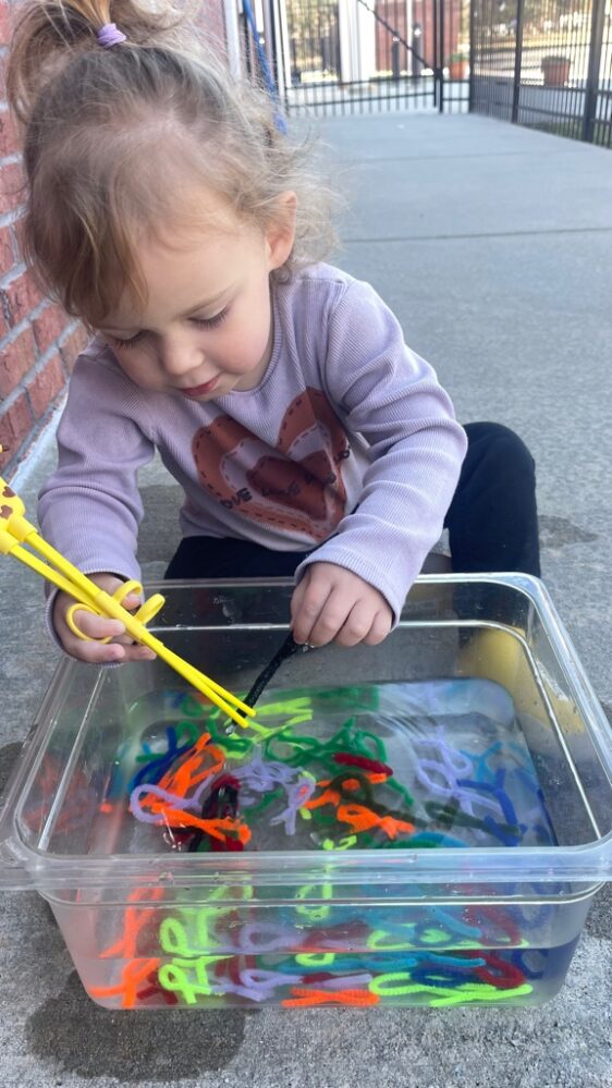 girl playing with water and toys.